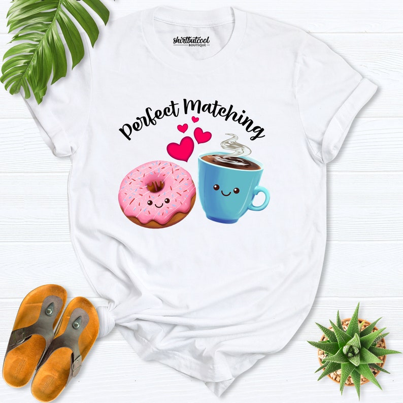 May include: White t-shirt with the text "Perfect Matching" and a pink donut and blue coffee cup with smiling faces.