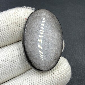 Obsidiaan cabochon zilverglans... Ovale cabochon... 37 x 24 x 6 mm... 43 kts... A#N5645