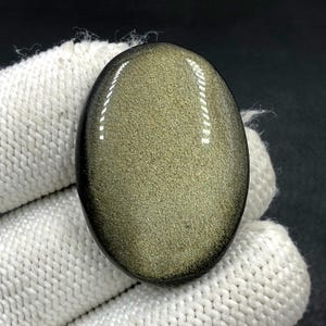 Obsidiaan cabochon goudglans... ovale cabochon... 36 x 26 x 6 mm... 42 kts... A#N5433