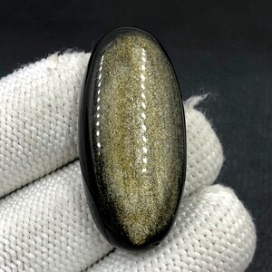 Obsidiaan cabochon goudglans... Ovale cabochon... 41 x 20 x 8 mm... 50 kts... A#N5428