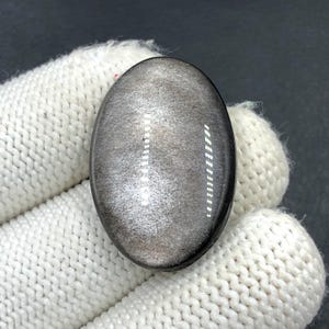 Obsidiaan cabochon zilverglans... Ovale cabochon... 31 x 21 x 6 mm... 30 kts... A#N5653