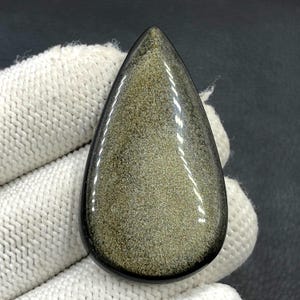 Cabochon met goudglanzende obsidiaan... Cabochon peer... 49 x 28 x 6 mm... 58 kts... A#N5451