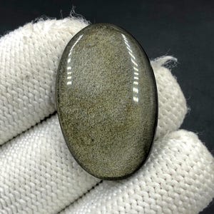 Obsidiaan cabochon goudglans... Ovale cabochon... 33 x 21 x 5 mm... 30 kts... A#N5438