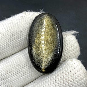 Obsidiaan cabochon goudglans... ovale cabochon... 32 x 19 x 5 mm... 24 kt... A#N5439