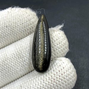 Cabochon met gouden glans Obsidiaan... Cabochon peer... 30 x 10 x 5 mm... 10 kt... A#N5458