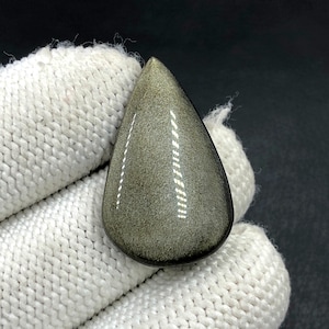 Cabochon met goudglanzende obsidiaan... Cabochon peer... 31 x 19 x 6 mm... 21 kt... A#N5454