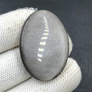 Obsidiaan cabochon zilverglans... Ovale cabochon... 38 x 27 x 6 mm... 48 kts... A#N5644