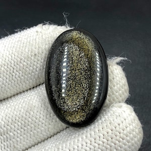 Obsidiaan cabochon goudglans... Ovale cabochon... 33 x 21 x 6 mm... 31 kts... A#N5436