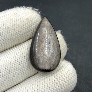 Obsidiaan cabochon met zilverglans... Cabochon peer... 30 x 17 x 7 mm... 22 kt... A#N5668