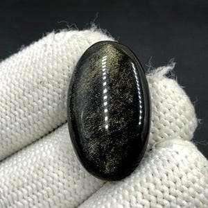 Obsidiaan cabochon goudglans... Ovale cabochon... 29 x 18 x 5 mm... 21 kts.... A#N5447