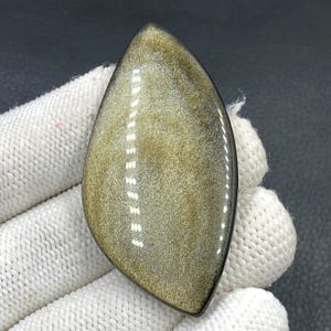 Cabochon met goudglanzende obsidiaan... Vrije vorm... 60 x 30 x 6 mm... 74 kts... A#N5463