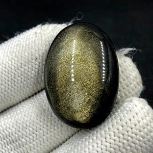 Obsidiaan cabochon goudglans... ovale cabochon... 32 x 23 x 9 mm... 51 kts... A#N5435