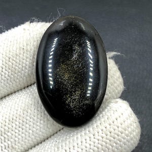 Obsidiaan cabochon goudglans... ovale cabochon... 36 x 23 x 6 mm... 39 kts... A#N5432