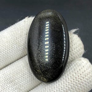 Obsidiaan cabochon goudglans... Ovale cabochon... 41 x 24 x 6 mm... 42 kts... A#N5429