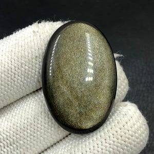 Obsidiaan cabochon goudglans... Ovale cabochon... 37 x 24 x 6 mm... 43 kts... A#N5431