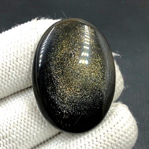 Obsidiaan cabochon goudglans... ovale cabochon... 37 x 27 x 5 mm... 36 kts... A#N5430