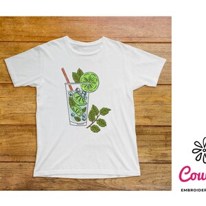 May include: White t-shirt with a graphic of a glass of mojito with a lime wedge and a sprig of mint.