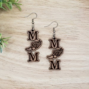 May include: A pair of wooden earrings with a winged shoe and the letter "M" on each earring.