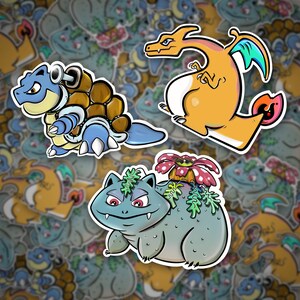 May include: Three cartoon stickers featuring Pokemon characters. The first sticker is a blue and brown turtle-like Pokemon with a red eye. The second sticker is a yellow and orange dragon-like Pokemon with a green and blue wing. The third sticker is a blue and green dinosaur-like Pokemon with a pink flower on its head.