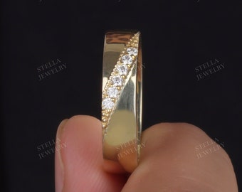 May include: A gold wedding band with a diagonal row of small diamonds.