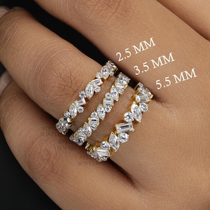 May include: Three gold rings with a row of small, clear, baguette-shaped diamonds. The rings are labelled 2.5 MM, 3.5 MM, and 5.5 MM.