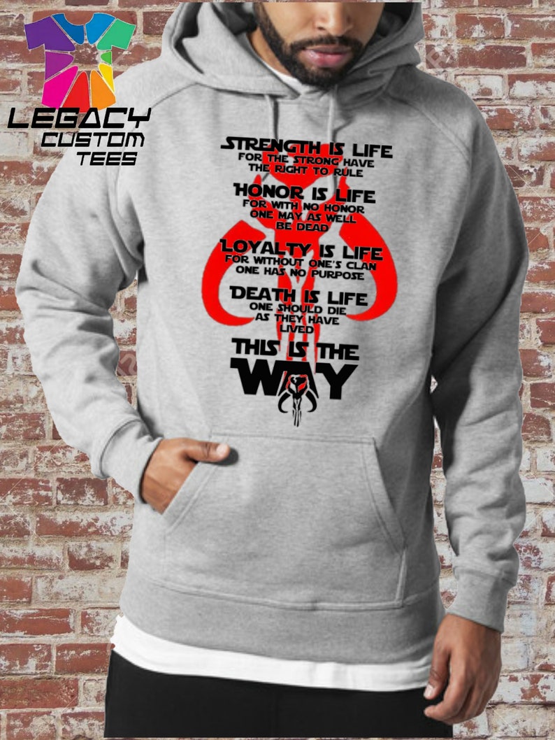 May include: A gray hooded sweatshirt with a black and red graphic print. The graphic features a Mandalorian symbol and text that reads "Strength is life for the strong have the right to rule. Honor is life for with no honor one may as well be dead. Loyalty is life for without one's clan one has no purpose. Death is life one should die as they have lived. This is the way."
