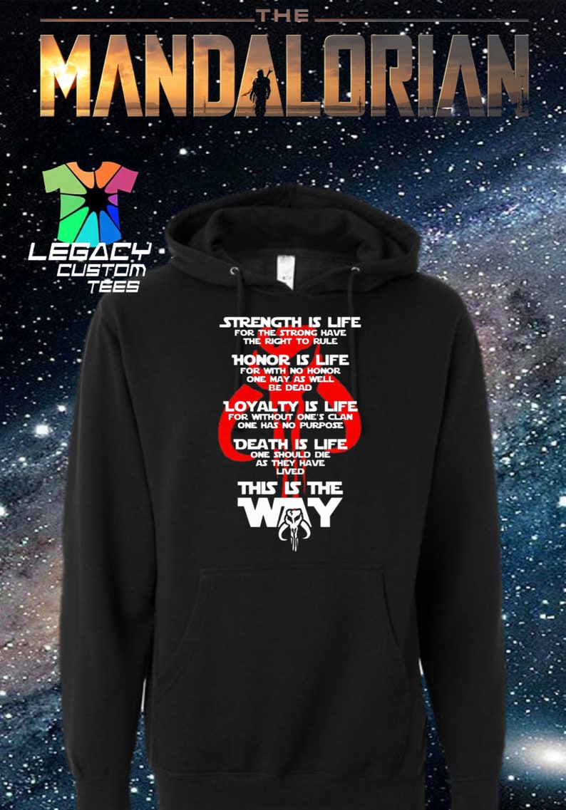 May include: Black hooded sweatshirt with a white graphic print of the Mandalorian symbol and the text "This is the Way". The graphic also includes the words "Strength is life", "Honor is life", "Loyalty is life", and "Death is life".