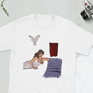 Könnte beinhalten: Weißes T-Shirt mit einer Illustration einer Frau in einem weißen Kleid, einer Taube und abstrakten Formen. Das Kunstwerk hat einen minimalistischen Stil mit einer Farbpalette aus Weiß, Braun und Lila.