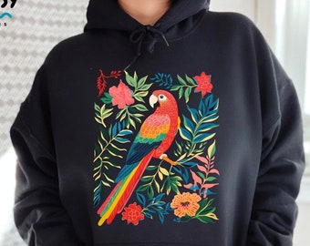 May include: Black hoodie with a colorful parrot and floral design. The parrot is red, yellow, blue, and green. The flowers are pink, orange, and yellow. The design is surrounded by green leaves.