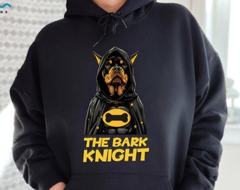May include: Black hoodie with a graphic of a Doberman Pinscher dressed as Batman. The graphic includes a yellow bone in the Batman logo and the text "The Bark Knight".
