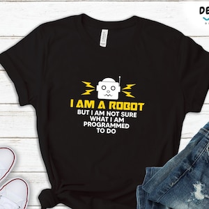 May include: Black t-shirt with a white robot graphic and yellow text that reads "I am a robot but I am not sure what I am programmed to do".