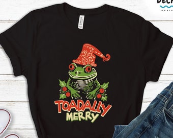 May include: Black t-shirt with a green frog wearing a red Santa hat and holly. The text "TOADALLY MERRY" is printed below the frog.
