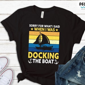 May include: Black t-shirt with a vintage sunset graphic of a sailboat and the text "Sorry for what I said when I was docking the boat".