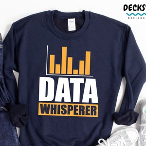 May include: A navy blue sweatshirt with a white graphic that says "DATA WHISPERER" with a yellow bar graph above the text.