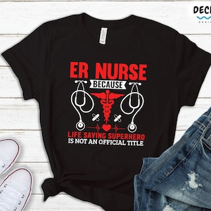 Puede incluir: Camiseta negra con texto rojo que dice "ER Nurse because life saving superhero is not an official title". El texto está rodeado por un estetoscopio y un símbolo médico.