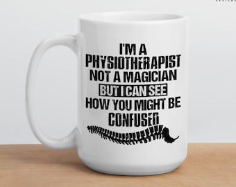 May include: White ceramic mug with a black graphic that reads "I'm a Physiotherapist not a Magician but I can see how you might be confused."  The graphic also includes a black silhouette of a spine.
