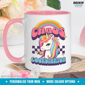 Puede incluir: Taza de cerámica blanca con borde y asa de color rosa. La taza presenta un arcoíris, un unicornio con una corona de flores y el texto "Chaos Coordinator".