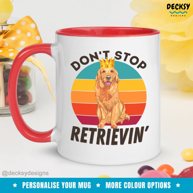 K&ouml;nnte beinhalten: Wei&szlig;e Keramiktasse mit rotem Rand. Die Tasse zeigt eine Grafik im Retro-Stil mit einem Sonnenuntergang und einem Golden Retriever, der eine Krone tr&auml;gt. Der Text "Don't Stop Retrievin'" ist in Schwarz unter der Grafik aufgedruckt.