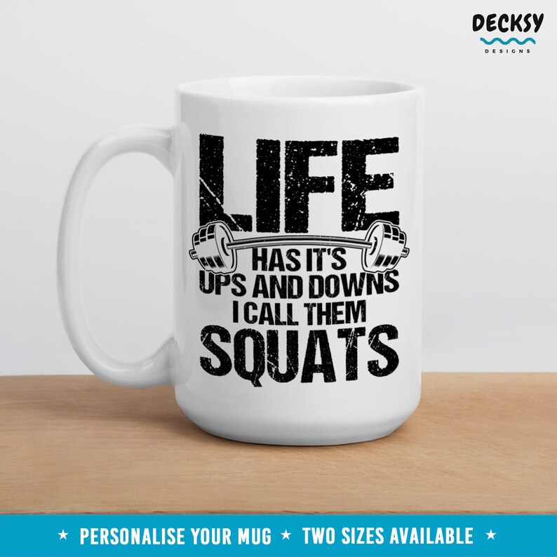May include: White ceramic mug with a black graphic that reads "Life has it's ups and downs I call them squats".