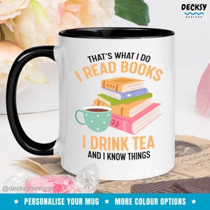 Op de afbeelding: Witte keramische mok met een zwarte rand en handvat. De mok heeft een afbeelding van een stapel boeken, een kopje thee en de tekst "That's what I do I read books I drink tea and I know things".