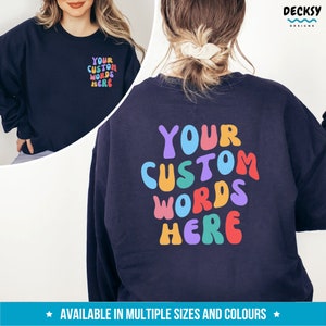 May include: A navy blue sweatshirt with the text "YOUR CUSTOM WORDS HERE" in colorful, rounded letters. The text is on the back of the sweatshirt.