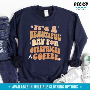 May include: Navy blue sweatshirt with a retro-style graphic that reads "It's a beautiful day for overpriced coffee".