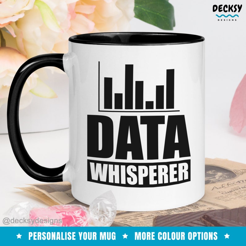 May include: White ceramic mug with a black rim and handle. The mug has a black graphic of a bar chart and the text "DATA WHISPERER".