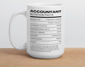 May include: White ceramic coffee mug with a black design that reads "Accountant Nutrition Facts". The design is formatted like a nutrition label with categories such as "Attention to Detail", "Organisational Skills", "Critical Thinking", "Caffeine", "Hardworking", and "Regret". The mug has a black handle and a white background.