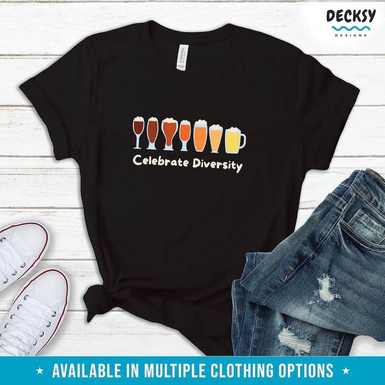 May include: Black t-shirt featuring the phrase "Celebrate Diversity" and a line of beer glasses in different colours. The shirt is shown with blue jeans and white trainers. Available in multiple clothing options.