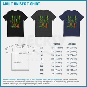 May include: Adult unisex t-shirt with a forest scene graphic. The shirt is available in black, heather grey, and navy blue. The size chart shows the width and length of the shirt in inches and centimeters.