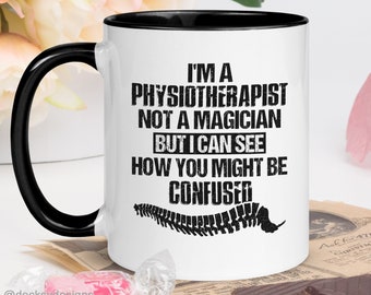 May include: White coffee mug with a black rim and handle. The mug features a black and white graphic of a spine with the text "I'm a Physiotherapist not a magician but I can see how you might be confused".