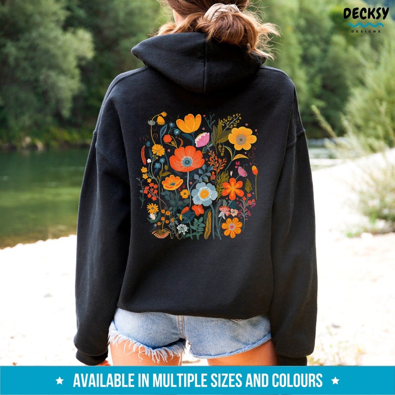 May include: Black hooded sweatshirt with a colorful floral print on the back. The print features a variety of flowers in shades of orange, yellow, red, blue, and green.
