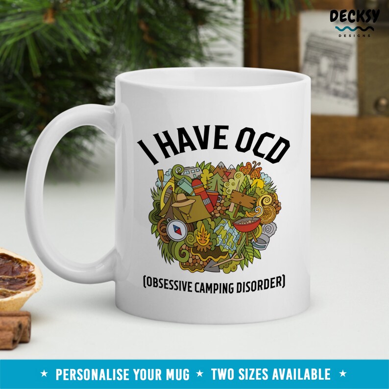 May include: White ceramic mug with a black and green illustration of camping gear and the text "I HAVE OCD [OBSESSIVE CAMPING DISORDER]".