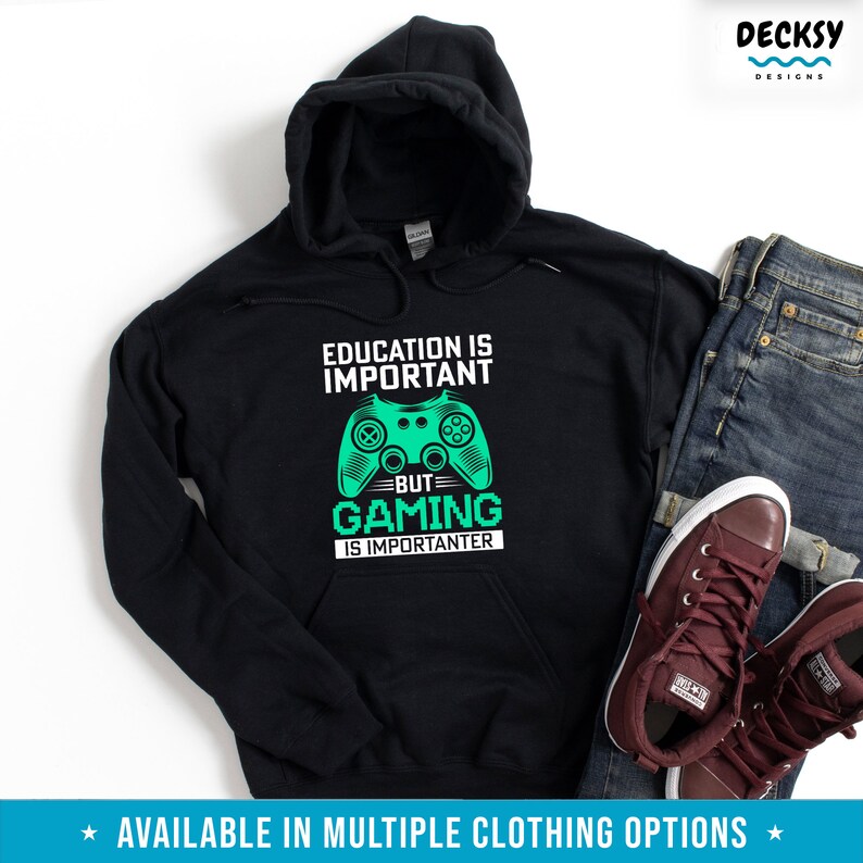 K&ouml;nnte beinhalten: Schwarzer Kapuzenpullover mit einem gr&uuml;nen Videospiel-Controller-Motiv und dem Text "Bildung ist wichtig, aber Gaming ist wichtiger".